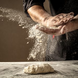 Hands Dusting Flour Onto Fresh Dough