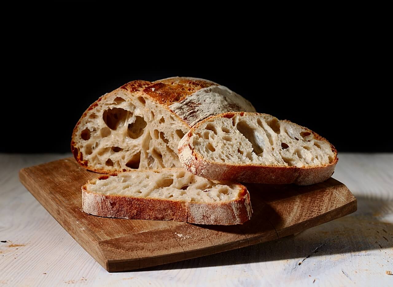 Freshly Baked Sourdough On Wooden Board